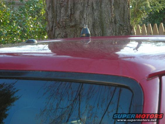 Red SUV roof with a black antenna and a shark fin antenna base