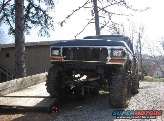 Dark blue 1979 Ford Bronco with large tires on a trailer, front view