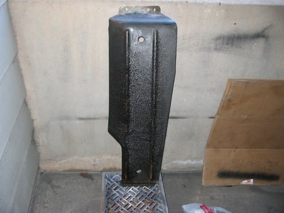 Black metal part with textured finish, mounted on a grate