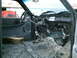 2001 Dodge 2500 - The interior of a truck cab shows significant modifications and a stripped-down appearance, with a block of wood on the floor.