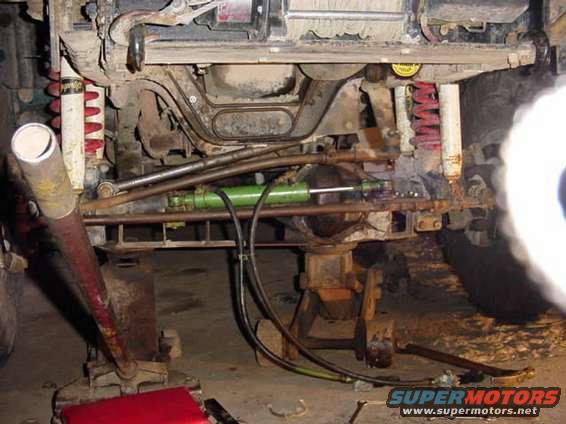 ramounted.jpg ram mounted on axle.  uses tapered tie rod ends. clear everything just barely.  we flex tested it with the loader tractor and it doesnt bind of hit anything, almost nails the pitman arm near the drag lin on one side compression with the wheel dead ahead, but it scrapes by.