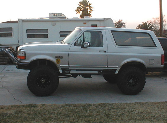 1996 Ford Bronco side profile, lifted with large off-road tires and custom front bumper