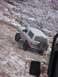 1996 Ford Bronco - A 1996 Ford Bronco navigates a challenging, snow-dusted rocky incline, with another vehicle's mirror in view.