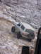 1996 Ford Bronco - White 1996 Ford Bronco navigates a challenging rocky incline with snow and ice on the terrain.