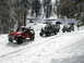 1996 Ford Bronco - Several off-road vehicles navigate a snowy mountain pass.