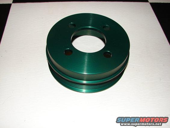 Green pulley with four bolt holes and grooved circumference on a white surface