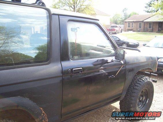 Black 1989 Ford Bronco II side view showing door and fender with large tires