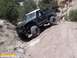 1986 Ford Bronco - Off-road Bronco navigating a steep, rocky incline on a dirt trail.