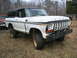1979 Ford Bronco - This white Ford Bronco, likely a 1978 model, sits in a grassy lot with another vehicle partially visible.