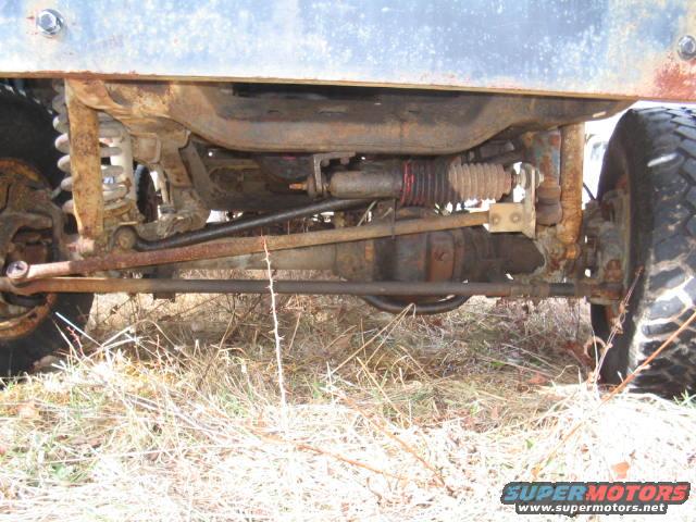 Undercarriage view showing suspension and drivetrain components of an older vehicle