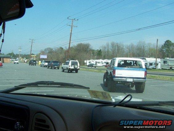 Lifted 1996 Ford Bronco with off-road tires, seen from inside another vehicle