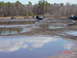 1995 Dodge 1500 - Trucks navigate a muddy off-road park, with several vehicles partially submerged in water and mud.