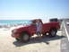 2001 Mazda B3000 - Red 2001 Mazda B3000 pickup truck parked on a sandy beach with the ocean in the background.