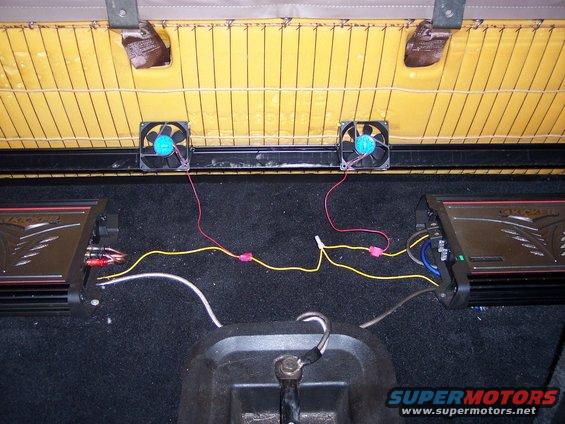 Here are the two PC cooling fans I mounted under the back seat to cool the amps.  I fastened them to the underside of the seat using cable ties.  I tapped power for them from the remote wires for the amps and grounded them to the seat frame.  I also removed the remainder of the fiberboard panel attached to the bottom of the seat in order to improve airflow.