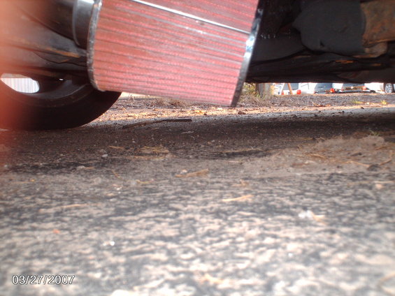 Red air intake filter attached to exhaust pipe, viewed from below