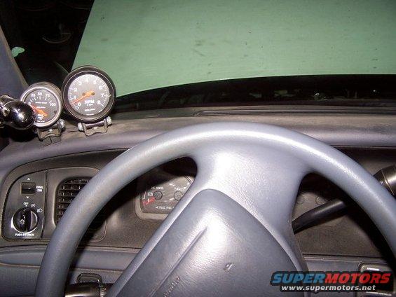 Dashboard with steering wheel, tachometer, and oil pressure gauge. Fuel gauge visible in dash
