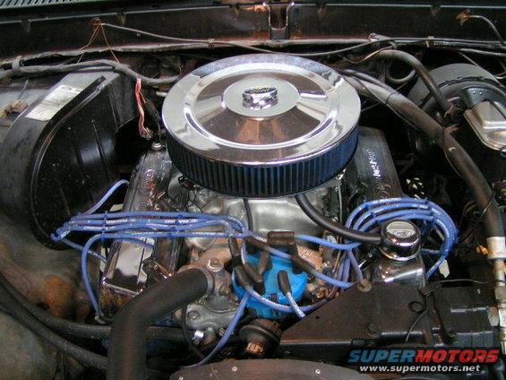 Engine bay of a 1979 Ford Bronco with a chrome air cleaner and blue spark plug wires