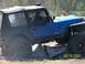 1989 Ford Bronco - A blue Jeep Wrangler navigates an obstacle course with another Jeep visible in the distance.