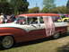 1966 Ford Ranchero - A vintage two-tone station wagon is parked on grass with other vehicles in the background.