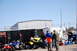 1996 Ford Bronco - ATVs are parked outside a trailer with a group of people nearby on a sunny day.