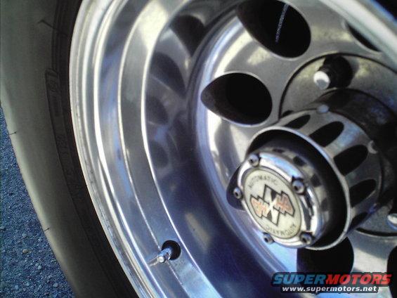 Close-up of a chrome wheel with a black tire and a hubcap with 'AUTOMATIC' text and a '4x4' logo