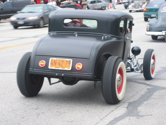 Black hot rod coupe with white-wall tires and red rims, rear view, license plate AN 42 79