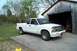 1988 Ford Bronco - This white Chevrolet S-10 pickup truck is parked outside a rustic wooden shed.