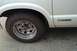 1988 Ford Bronco - A white pickup truck's side is shown, a chrome wheel and an "S10" badge.