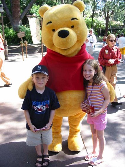 Winnie the Pooh costume with a boy and a girl, outdoors
