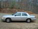 2004 Ford Crown Victoria - Side view of a silver 2004 Ford Crown Victoria parked outdoors.