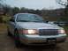 2004 Ford Crown Victoria - This 2004 Ford Crown Victoria is shown from the front, its distinctive chrome grille and illuminated headlights.