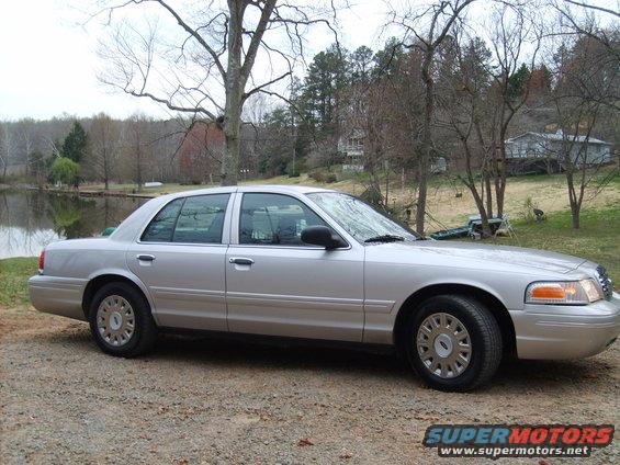 2004 Ford Crown Victoria parked on a gravel area next to a body of water