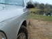 2004 Ford Crown Victoria - A silver 2004 Ford Crown Victoria is parked on a dirt path next to a lake with a picnic table in the background.
