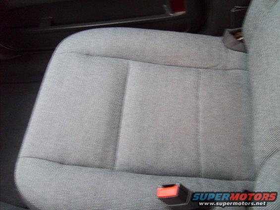 Gray fabric car seat with a red seatbelt buckle visible