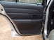 2004 Ford Crown Victoria - Interior view of a car's door panel, showing black plastic trim and a door handle.