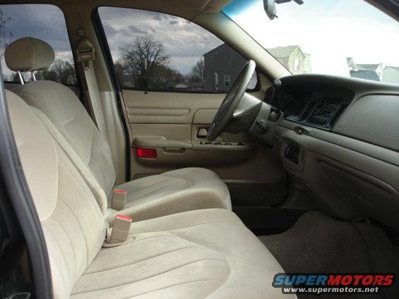 Tan interior of a 2001 Ford Crown Victoria showing front seats, dashboard, and steering wheel