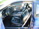 1995 Ford Thunderbird - The interior of a blue car features black leather seats and a dashboard visible through the open door.