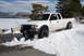 1989 Ford Bronco - A white Toyota Tacoma navigates a snowy road beside a frozen lake.
