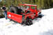 1989 Ford Bronco - A red off-road vehicle with oversized tires is stuck in deep snow, with people standing nearby.