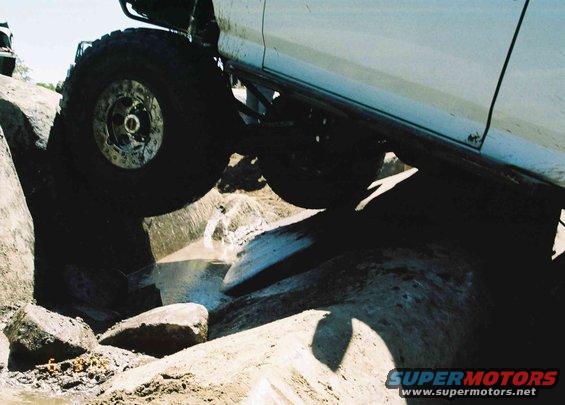 White 1995 Ford Bronco side view navigating rocky terrain