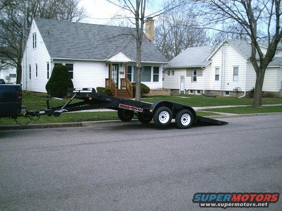 Black tandem axle trailer parked on street