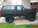 1970 Mercury Cougar - This lifted SUV features oversized tires and a matte black finish, presented in a side profile view.