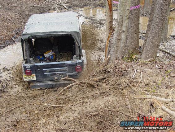Black Jeep Wrangler stuck in mud, rear view, license plate RBR-93M