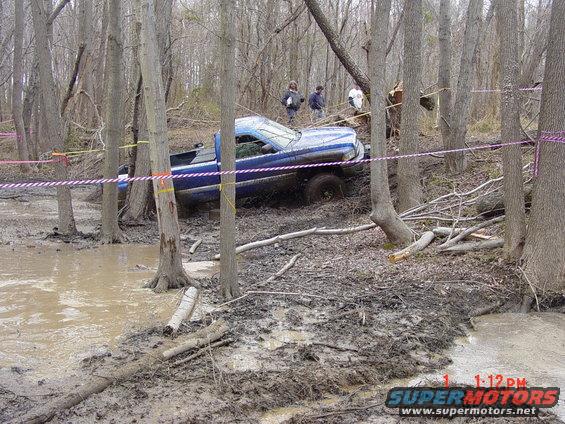 Blue 1995 Dodge 1500 stuck in mud and trees during an off-road event