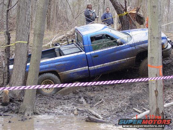 1995 Dodge 1500 pickup truck stuck in muddy terrain with two people watching