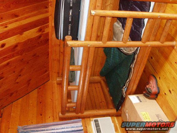 Interior of a wooden cabin with bunk beds, sleeping bags, and a boot