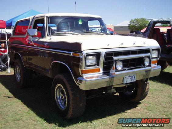 1978 Ford Bronco with two-tone paint and "I-TRUCK" license plate parked on grass