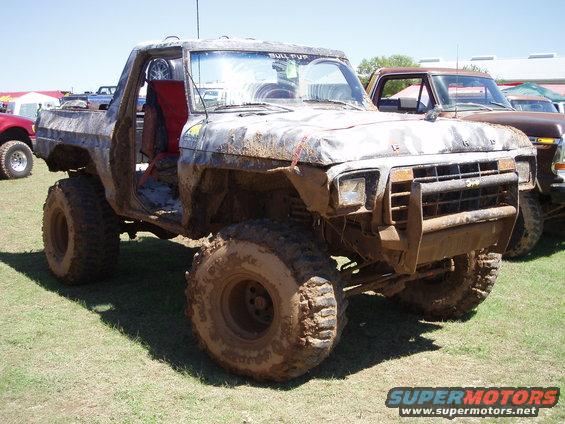 Muddy off-road truck with no doors, another truck behind it