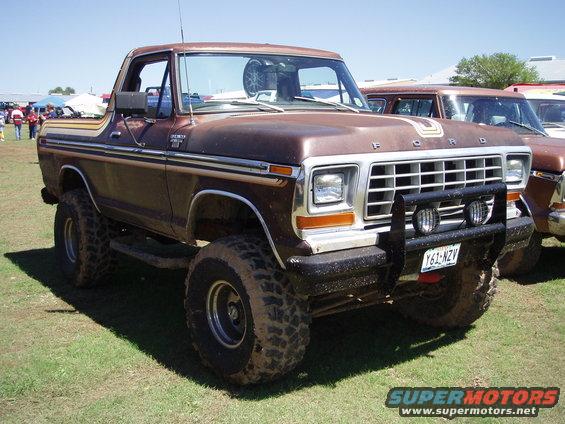 Brown 1978 Ford Bronco with lifted suspension and off-road tires, parked on grass