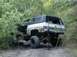 1996 Ford Bronco - This 1973 Chevrolet K5 Blazer is stuck in the mud, with 'ROLL & RECOVERY' visible on its tailgate.